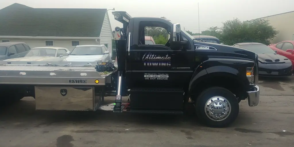 The black Ultimate Towing Ford F-650 flatbed, side profile